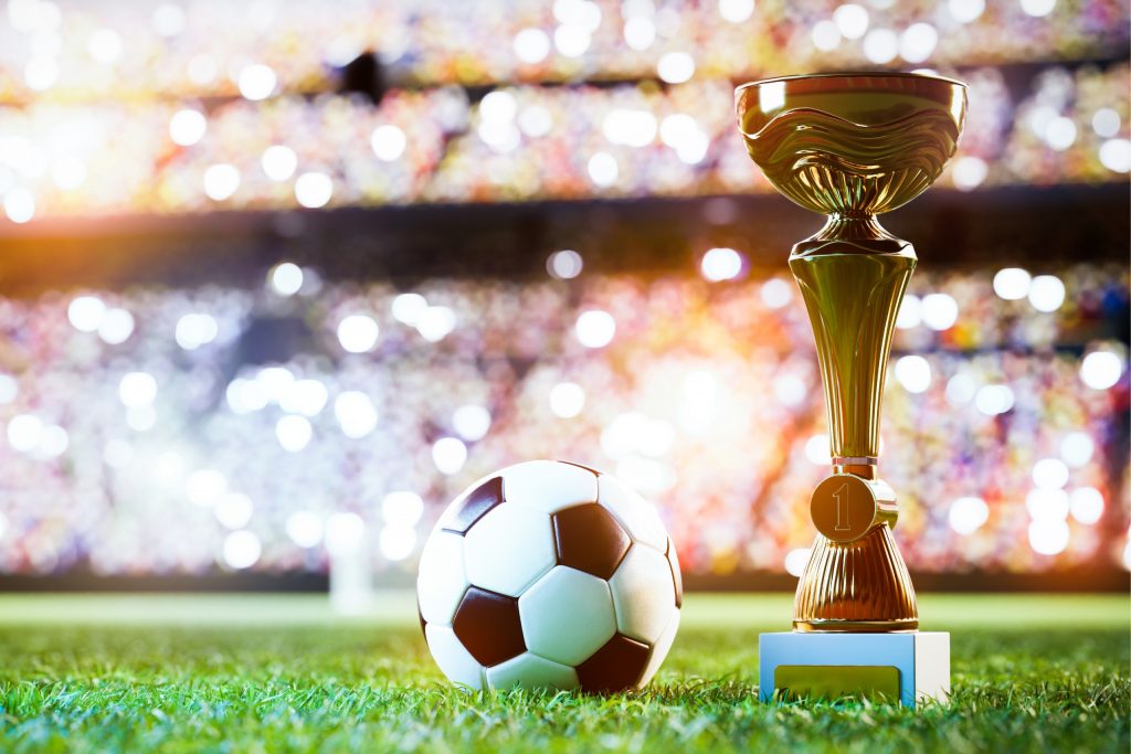 Football soccer ball and trophy cup on stadium